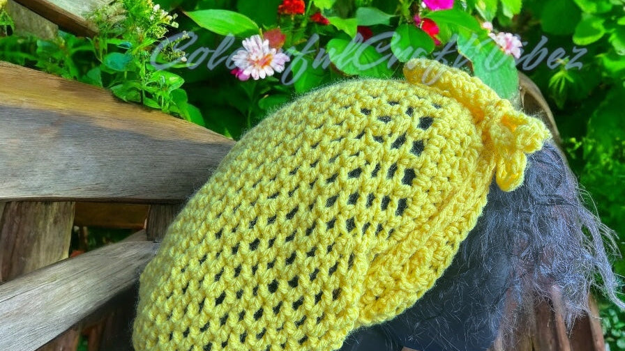 Crochet Mesh Hat Next to fence with flowers